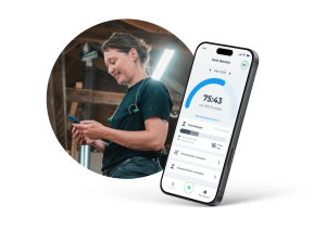 Handwerkerin schaut lächelnd auf ihr Smartphone in einer Werkstatt; daneben zeigt ein Screen die clockin App mit dem Bereich "Mein Bereich" inklusive Monatsstunden, Urlaubstagen und Menüpunkten für Arbeitszeiten und Abwesenheiten.