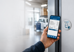 Person hält Smartphone mit geöffneter MomoZeit-App an einen MomoZeit-NFC-Sticker an der Wand, um die Arbeitszeit per NFC zu erfassen.