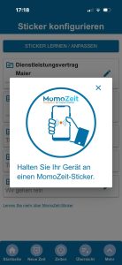 MomoZeit-App zeigt den Dialog „Sticker konfigurieren" mit Anleitung, das Smartphone an einen MomoZeit-NFC-Sticker zu halten, sowie eine Liste bereits angelegter Projekte im Hintergrund.